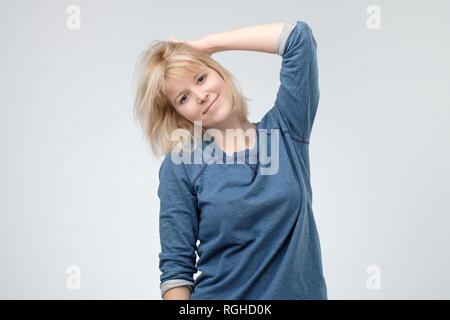 Junges Mädchen mit blonden Haaren Spaß drinnen, und wenn man die Kamera mit fröhlichen Lächeln. Stockfoto