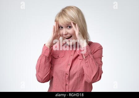 Schöne Frau im roten Kleid stehen gegen weiße Wand Stockfoto