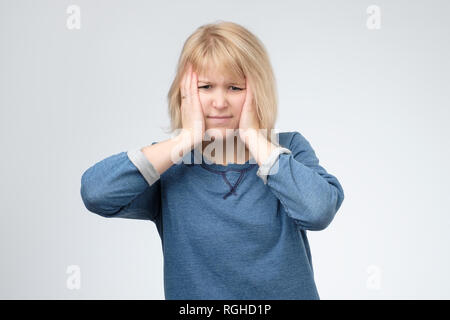 Blondine besorgt, Frau, die in einer verzweifelten Situation, Hände auf den Kopf. Sie verlor ihre Beutel mit Geld. Stockfoto