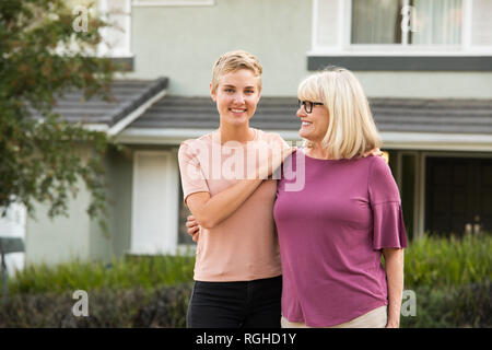 Porträt der lächelnde Frau mit Mutter vor einem Haus Stockfoto