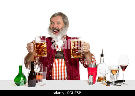 Das Senior Expert männlich Barkeeper mit Bier im Studio auf weißem Hintergrund. Internationale Barkeeper Tag, Bar, Alkohol, Restaurant, Bier, Party, Pub, St. Patrick's Day Celebration Konzept Stockfoto