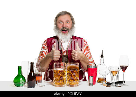 Das Senior Expert männlich Barkeeper mit Bier im Studio auf weißem Hintergrund. Internationale Barkeeper Tag, Bar, Alkohol, Restaurant, Bier, Party, Pub, St. Patrick's Day Celebration Konzept Stockfoto