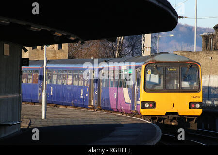 Klasse 144 Pacer diesel multiple Unit verlassen Carnforth Station mit einem personenzug am 28. Januar 2019 von Plattform zu Plattform gerahmt und geschwungenen Dach. Stockfoto