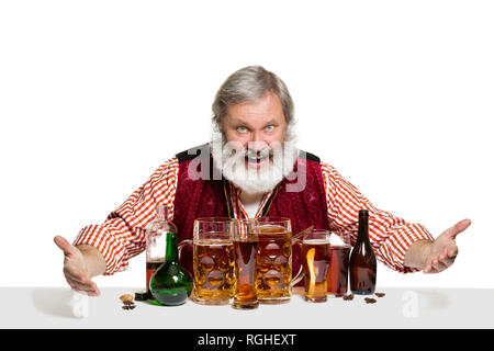 Das Senior Expert männlich Barkeeper mit Bier im Studio auf weißem Hintergrund. Internationale Barkeeper Tag, Bar, Alkohol, Restaurant, Bier, Party, Pub, St. Patrick's Day Celebration Konzept Stockfoto