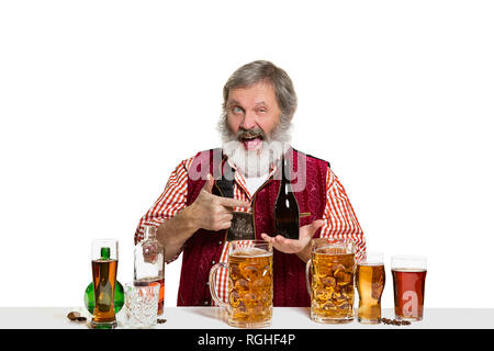 Das Senior Expert männlich Barkeeper mit Bier im Studio auf weißem Hintergrund. Internationale Barkeeper Tag, Bar, Alkohol, Restaurant, Bier, Party, Pub, St. Patrick's Day Celebration Konzept Stockfoto