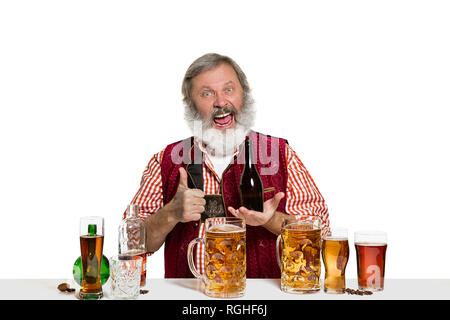 Das Senior Expert männlich Barkeeper mit Bier im Studio auf weißem Hintergrund. Internationale Barkeeper Tag, Bar, Alkohol, Restaurant, Bier, Party, Pub, St. Patrick's Day Celebration Konzept Stockfoto