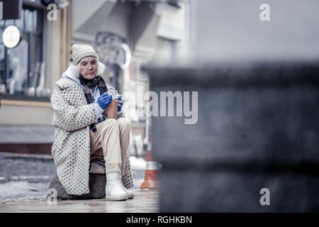 Traurig unglückliche Frau saß auf dem Stein Stockfoto