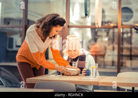 Positive Art Frau, eine Schüssel mit Suppe auf dem Tisch Stockfoto