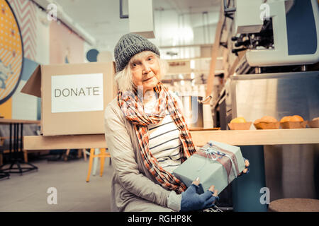 Schöne freudige obdachlose Frau ein Geschenk Stockfoto