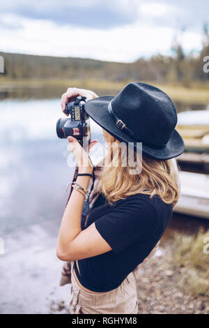 Schweden, Lappland, junge Frau mit schwarzen Hut, Fotos mit der Kamera Stockfoto