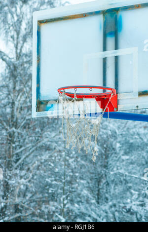 Gefrorene outdoor Basketballkorb im Winter Schnee auf leere sport Spielplatz Stockfoto