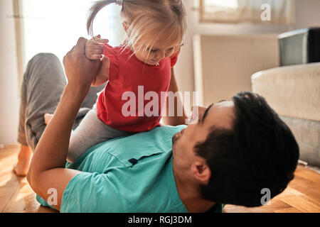 Kleine Mädchen spielen mit ihrem Vater zu Hause Stockfoto