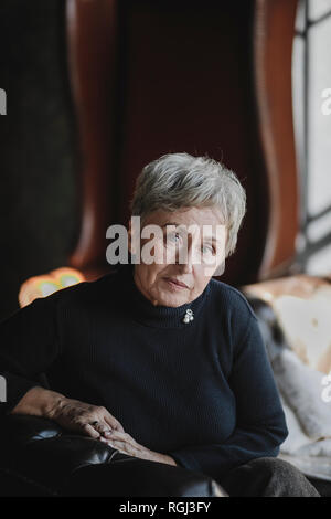 Porträt von senior Frau sitzt auf der couch Stockfoto