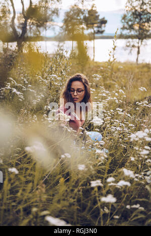 Junge Frau in Blumenwiese Stockfoto