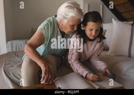 Großmutter ihrer Enkelin helfen bei Hausaufgaben Stockfoto