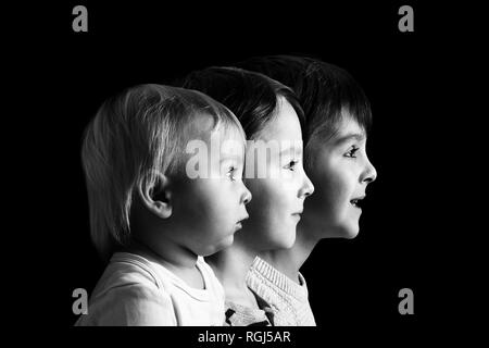 Family Portrait von drei Jungen, Profil Bild von Ihnen alle in einer Reihe, auf schwarzem Hintergrund, Farbe Version Stockfoto