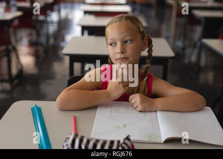 Nachdenklich Schulmädchen studieren im Klassenzimmer sitzen am Schreibtisch in der Schule Stockfoto