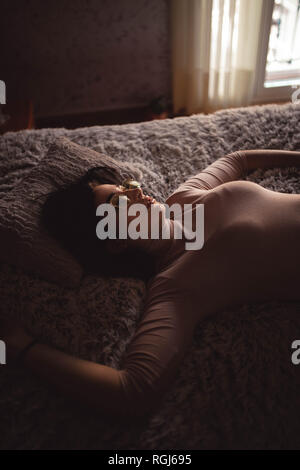 Junge Frau liegt auf dem Bett Stockfoto