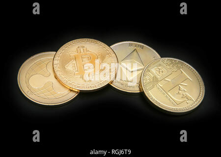 Litecoin, Welligkeit, des Astraleums & Bitcoin Goldmünzen, die cryptocurrenies vor einem schwarzen Hintergrund. Stockfoto