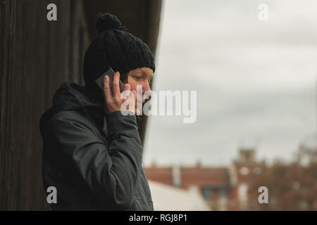 Besorgt Frau Gespräch am Handy auf der Straße in der Kälte des Winters Tag Stockfoto