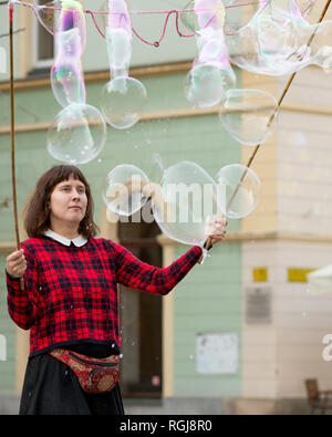 Junge weibliche Gaukler Blasen, die für Kinder zum Spielen im Zentrum von Breslau, Polen Stockfoto