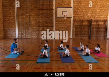 Seitenansicht des Yoga Lehrer yoga Kinder in der Schule gymnast zur Schule Stockfoto