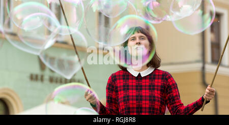 Junge weibliche Gaukler Blasen, die für Kinder zum Spielen im Zentrum von Breslau, Polen Stockfoto