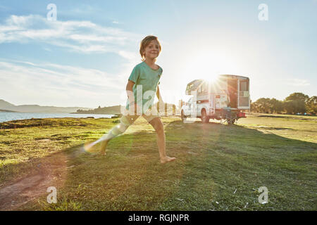 Chile, Talca, Rio Maule, Junge, die auf meadowbeside Camper am See Stockfoto