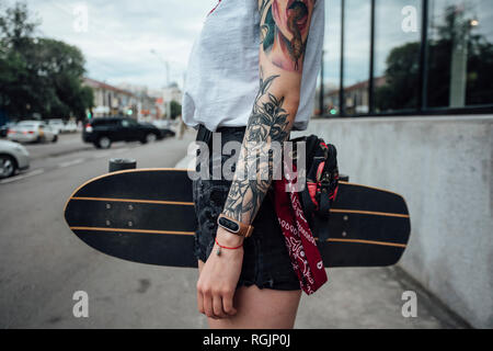 Close-up junge Frau mit Carver skateboard auf dem Bürgersteig Stockfoto