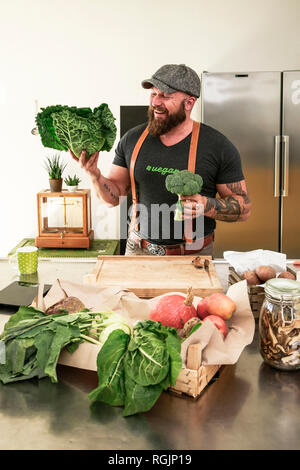 Vegan Mann sie Gemüse in seiner Küche Stockfoto