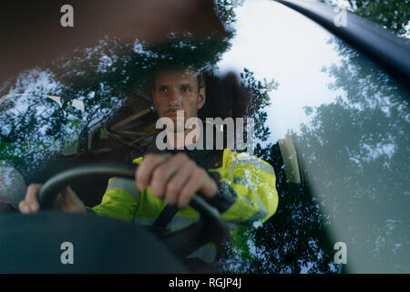 Mann in arbeitsschutzausrüstungen Auto Stockfoto