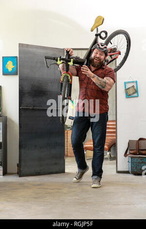 Portrait von Laughing man Fahrrad im Büro Stockfoto