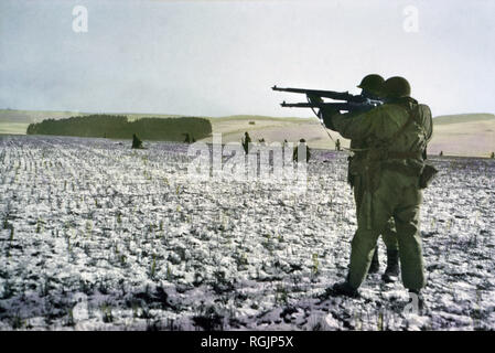 Infanteristen Feuer an den deutschen Truppen im Voraus zu entlasten Umgeben Fallschirmjäger, Bastogne, Belgien, Ardennes-Alsace Kampagne, Schlacht der Ausbuchtung, Dezember 1944 Stockfoto