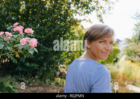 Porträt der lächelnde Frau im Garten Runden drehen Stockfoto