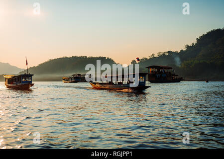 Sunset Cruise in Luang Prabang am Mekong. Weiches Licht auf die Boote im Wasser. Die meisten von Ihnen sind auf eine Bootsfahrt bei Sonnenuntergang. Stockfoto