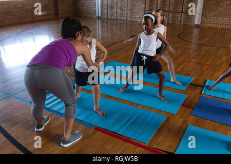 Junge weibliche Yoga Lehrer yoga Kinder in der Schule zu Schule Stockfoto