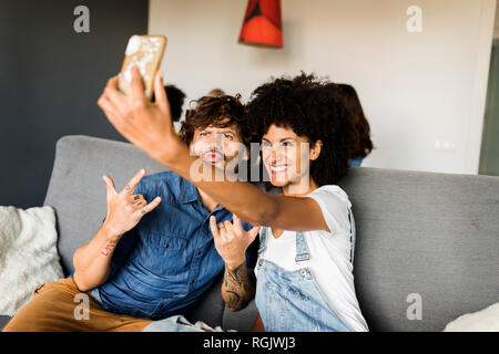 Glückliches Paar sitzt auf der Couch, ein selfie Stockfoto