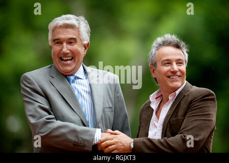 Zwei Geschäftsleute grinsen, als sie begeistert die Hände schütteln. Stockfoto