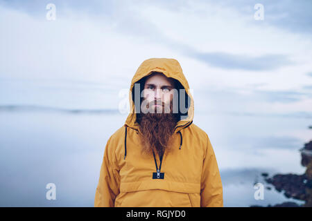 Schweden, Lappland, Portrait von schweren Mann mit Vollbart tragen gelbe Windjacke Stockfoto