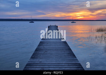 Holzsteg bei Sonnenuntergang an den Ammersee, Fuenfseenland, Bayern, Deutschland. Stockfoto