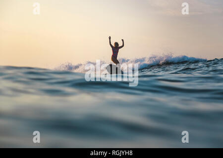 Indonesien, Bali, Batubolong Strand, Schwangere Frau surfen Stockfoto