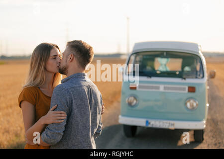 Junges Paar Küssen an Wohnmobil in ländlichen Landschaft Stockfoto