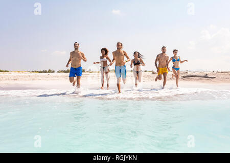 Gruppe von Freunden Spaß am Strand, die in das Wasser Stockfoto