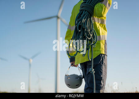 Nahaufnahme des Technikers an einen Windpark mit Kletterausrüstung Stockfoto