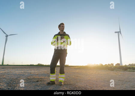 Techniker stehen in ländlichen Landschaft an einem Windpark Holding tablet Stockfoto