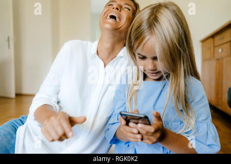 Lachen, Mutter und Tochter am Smartphone suchen Stockfoto