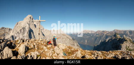 Deutschland, Bayern, Oberbayern, Berchtesgadener Land, Nationalpark Berchtesgaden, ehepaar am Gipfelkreuz Stockfoto