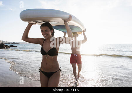 Frankreich, Bretagne, glückliches junges Paar Durchführung einer SUP Boards am Meer zusammen Stockfoto