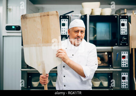 Portrait von Baker mit Schale in Bäckerei Stockfoto