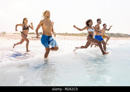 Gruppe von Freunden Spaß am Strand, die in das Wasser Stockfoto